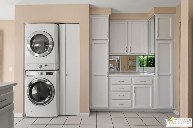 clothes washing area with stacked washing maching and dryer and light tile patterned floors