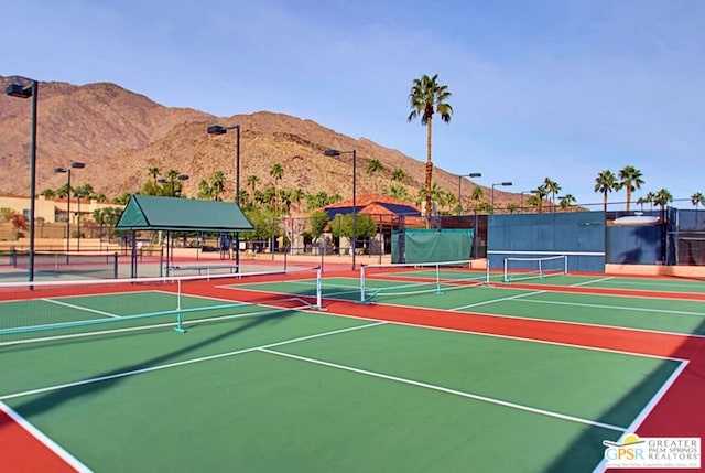 view of tennis court featuring a mountain view and basketball hoop