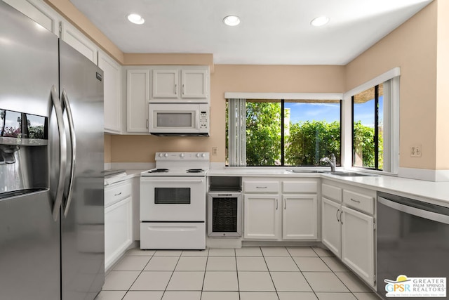 kitchen featuring light tile patterned flooring, white cabinetry, and stainless steel appliances