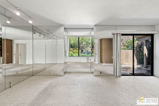 carpeted spare room featuring a textured ceiling