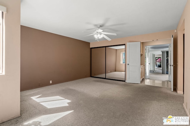 unfurnished bedroom featuring ceiling fan, light carpet, and a closet