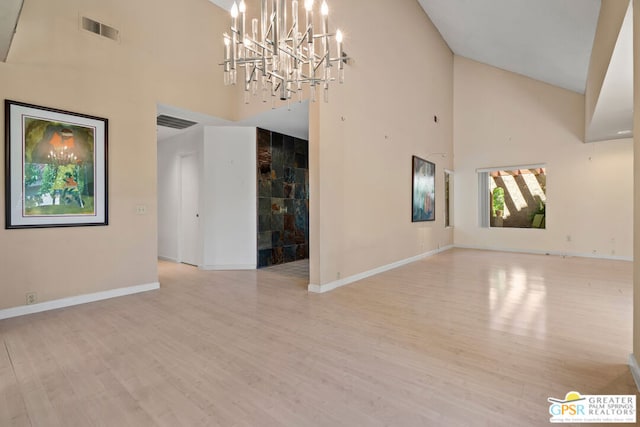 empty room with light hardwood / wood-style floors and high vaulted ceiling