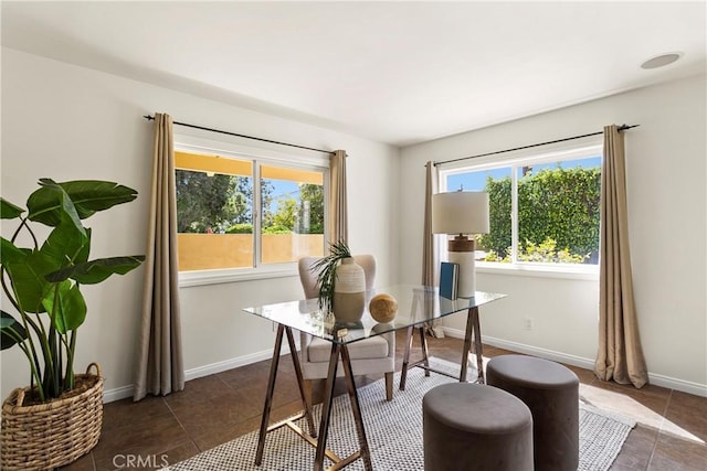 home office with plenty of natural light and dark tile patterned flooring