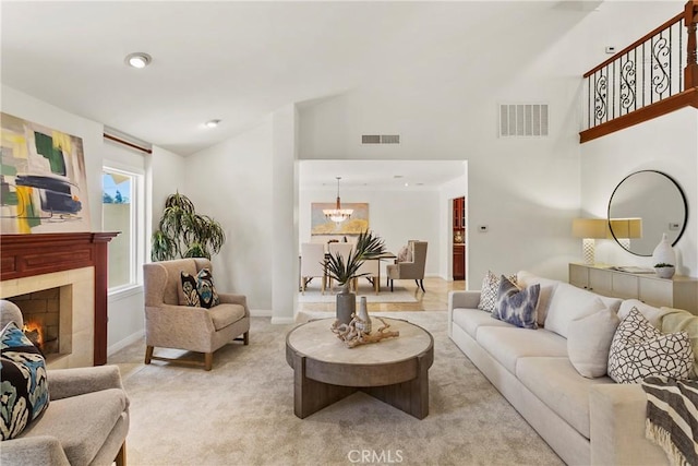 carpeted living room featuring an inviting chandelier