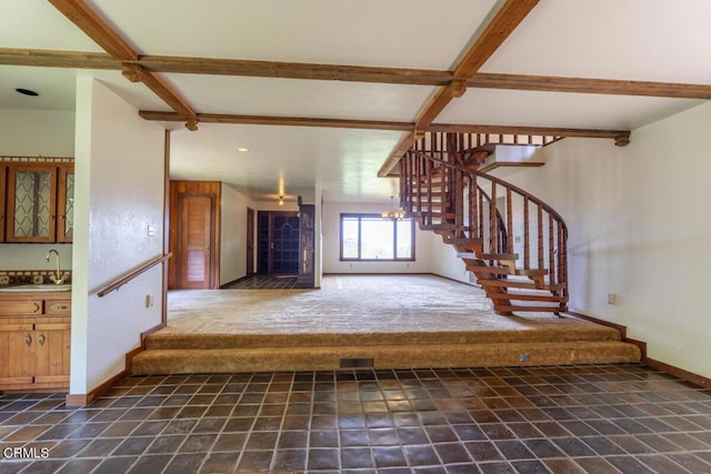 stairs featuring beam ceiling, baseboards, and wet bar