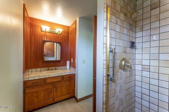 full bath with baseboards, a shower stall, and vanity