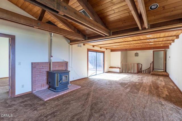 unfurnished living room featuring a wood stove, carpet flooring, wood ceiling, and lofted ceiling with beams