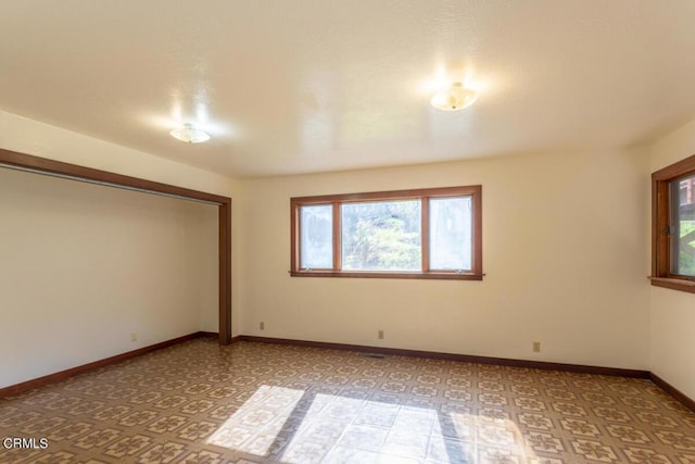 unfurnished room featuring baseboards and light floors