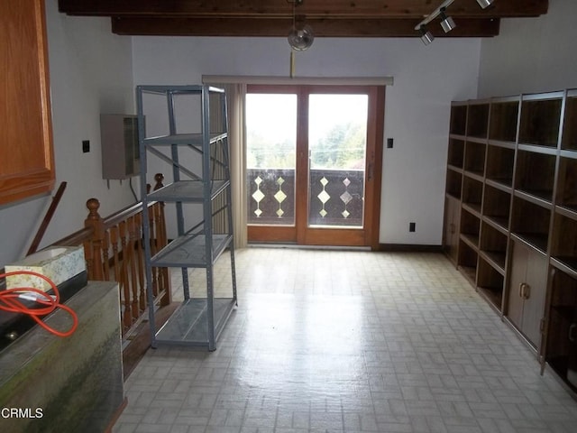 interior space with brick floor, baseboards, and beamed ceiling