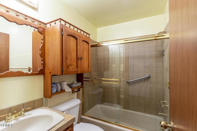 bathroom with toilet, shower / bath combination with glass door, and vanity