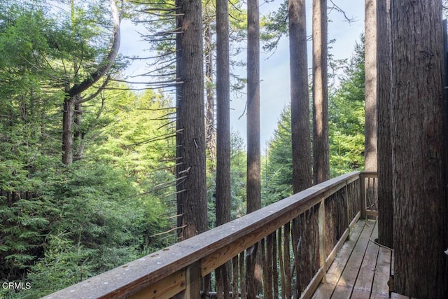 wooden deck with a forest view