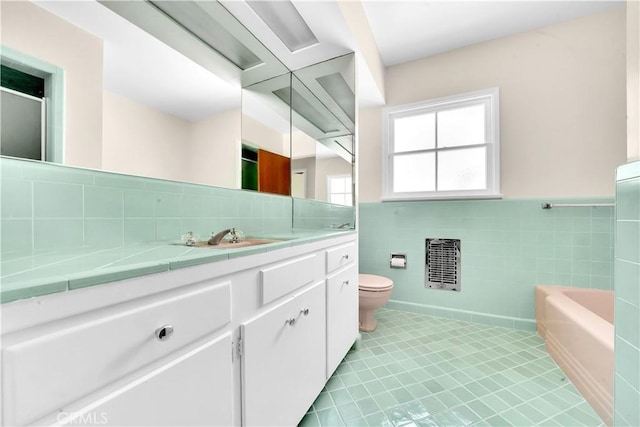 bathroom with vanity, toilet, a bathing tub, and tile walls