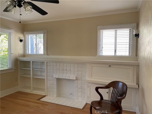 living area featuring crown molding, light hardwood / wood-style flooring, and ceiling fan