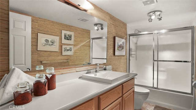 full bathroom with vanity, toilet, wooden walls, and enclosed tub / shower combo