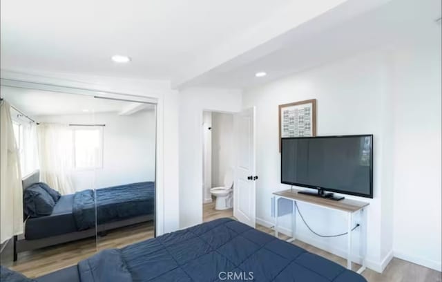 bedroom with ensuite bathroom and wood-type flooring