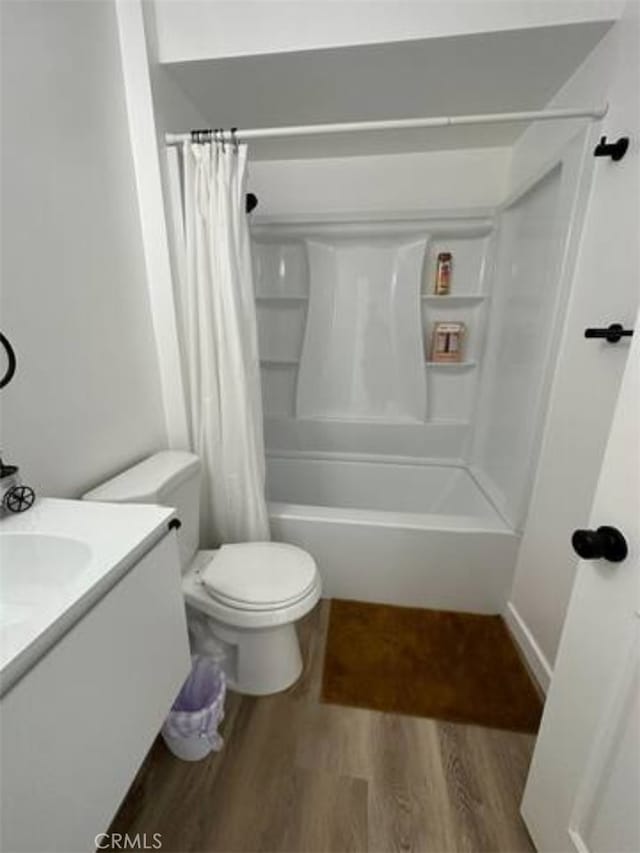 full bathroom with toilet, hardwood / wood-style floors, shower / bath combination with curtain, and vanity