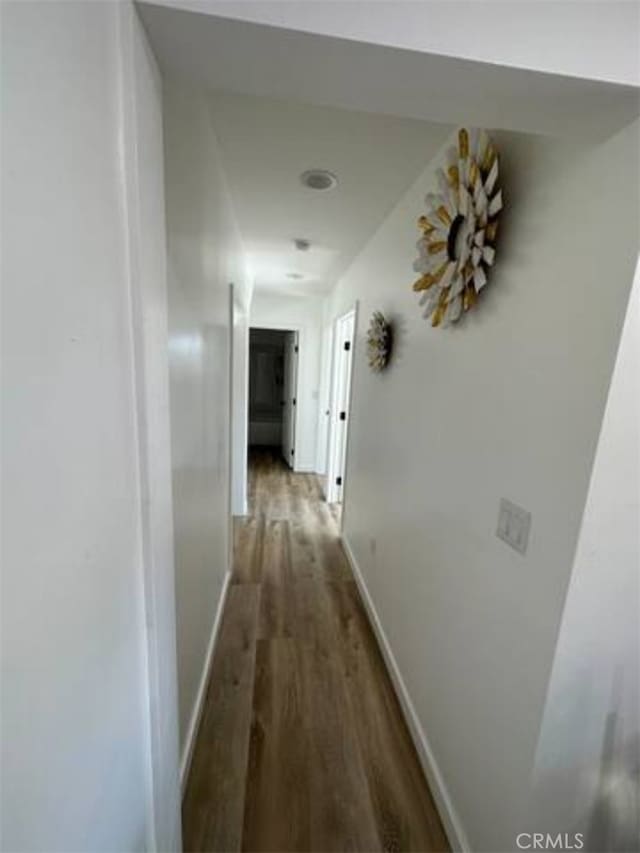 corridor with hardwood / wood-style flooring