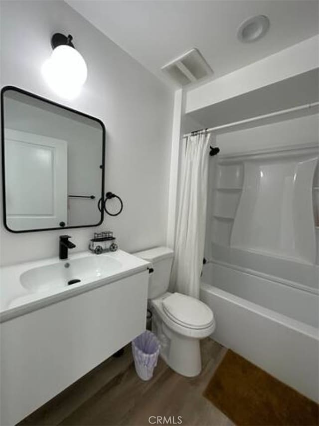 full bathroom with vanity, toilet, shower / bath combo with shower curtain, and hardwood / wood-style floors