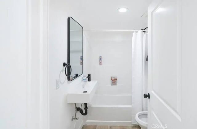 bathroom featuring shower / bath combo and toilet