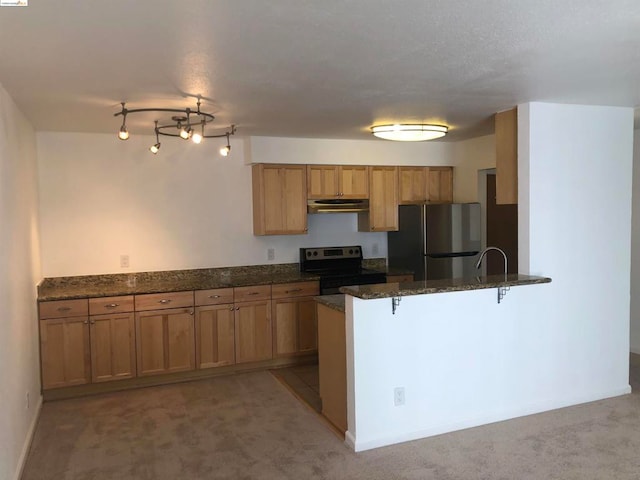 kitchen with stainless steel refrigerator, dark stone counters, light carpet, black range with electric cooktop, and kitchen peninsula