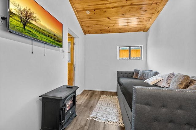 living room featuring hardwood / wood-style flooring, lofted ceiling, a wood stove, and wooden ceiling