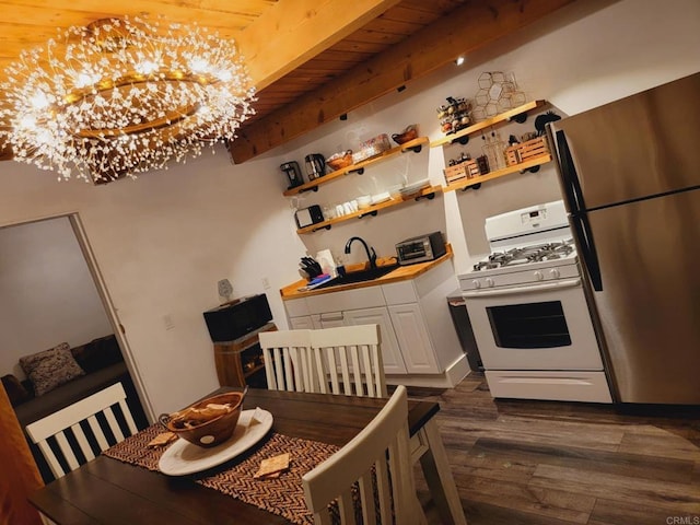 kitchen with white gas stove, beamed ceiling, a notable chandelier, wood ceiling, and stainless steel refrigerator