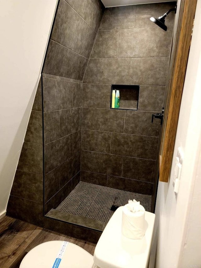 bathroom with tiled shower and toilet