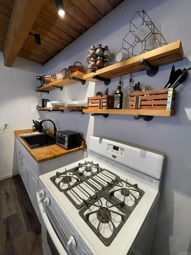 kitchen with gas range gas stove, wood ceiling, sink, dark hardwood / wood-style floors, and white cabinetry