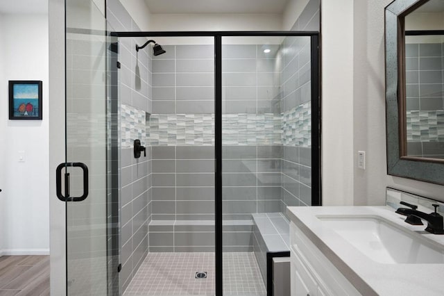 bathroom featuring hardwood / wood-style flooring, vanity, and an enclosed shower