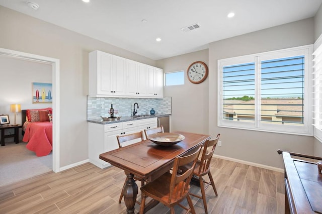 dining area with sink and light wood-type flooring