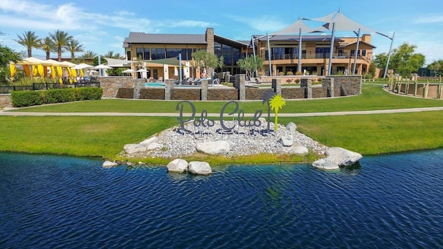 surrounding community featuring a water view and a lawn