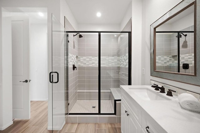 bathroom featuring vanity and a shower with door