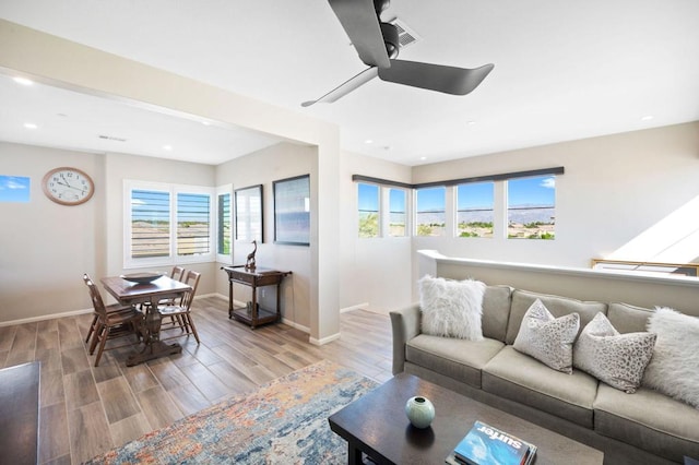 living room featuring ceiling fan and light hardwood / wood-style flooring