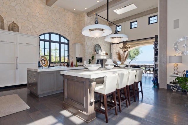 kitchen with beam ceiling, a healthy amount of sunlight, and dark hardwood / wood-style floors