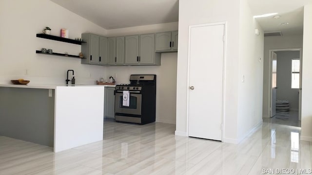 kitchen featuring sink, gas stove, and gray cabinetry