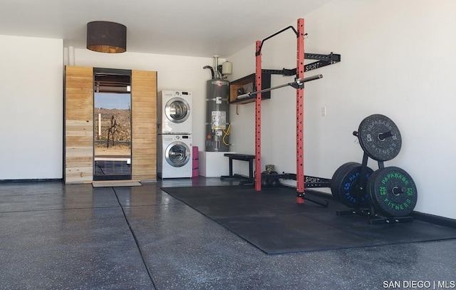 workout room featuring water heater and stacked washing maching and dryer