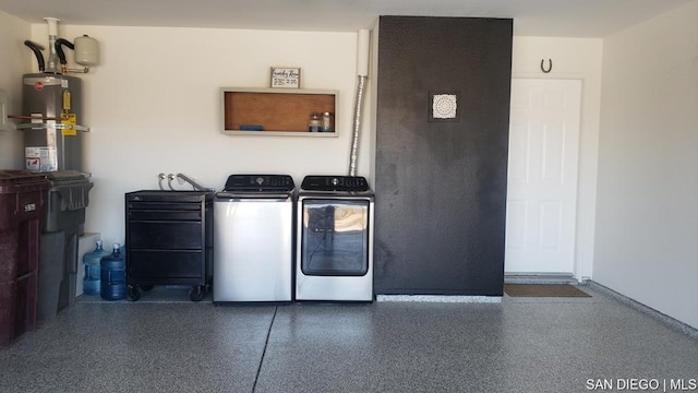 laundry room with strapped water heater and independent washer and dryer