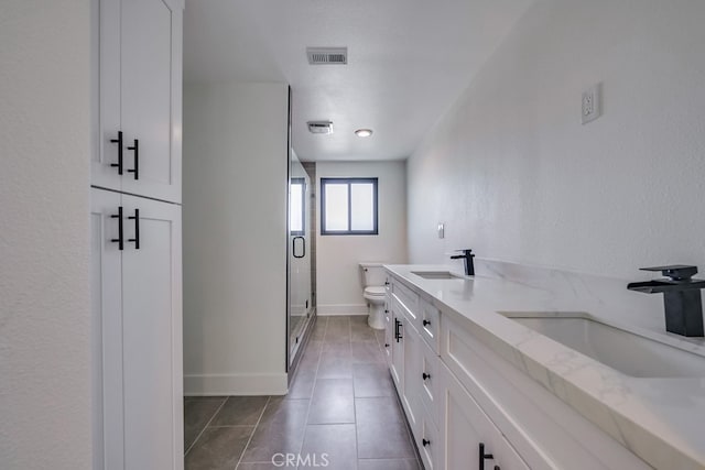 bathroom featuring vanity, toilet, an enclosed shower, and tile patterned floors