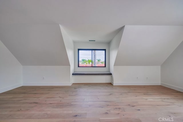 additional living space with lofted ceiling and light hardwood / wood-style flooring