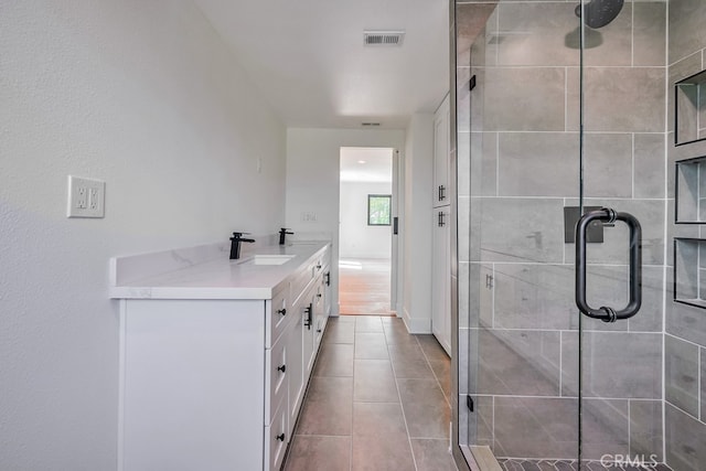 bathroom featuring vanity, an enclosed shower, and tile patterned floors