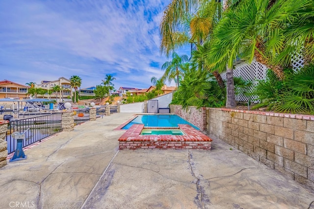 view of pool with a patio area and an in ground hot tub