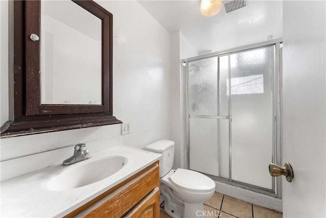 bathroom with tile patterned floors, vanity, toilet, and an enclosed shower