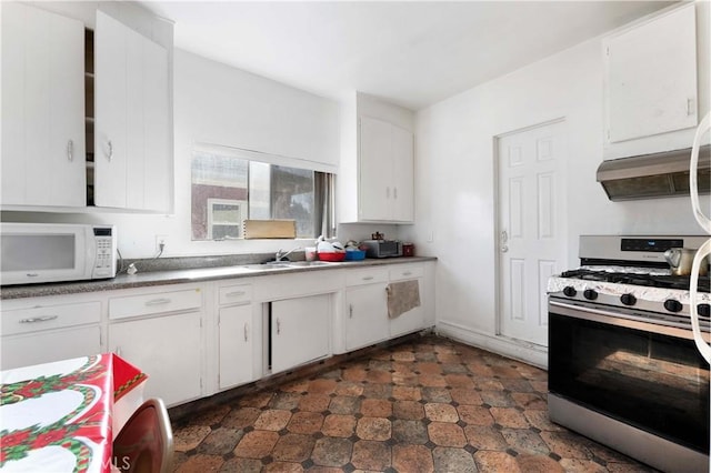 kitchen featuring stainless steel gas range oven, white cabinetry, sink, and ventilation hood