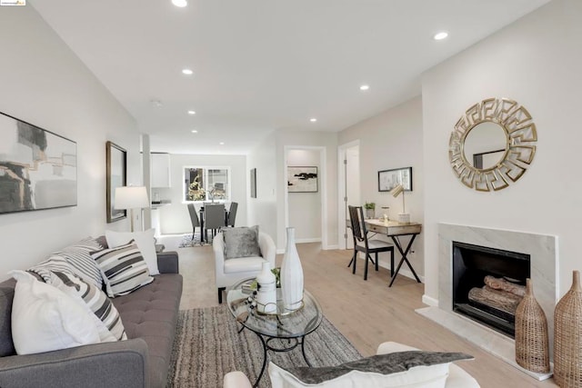 living room featuring light wood-type flooring and a fireplace