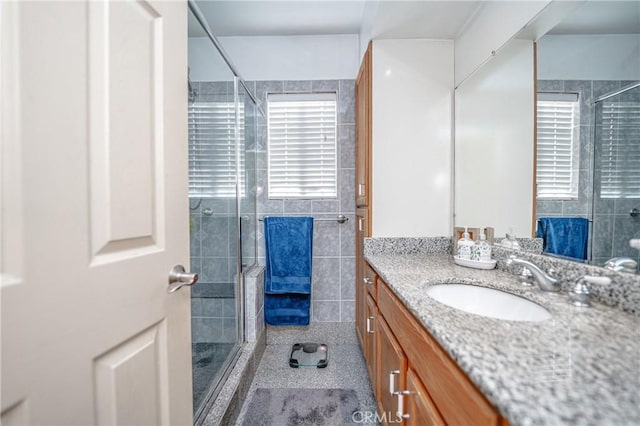 bathroom with tile patterned flooring, vanity, and an enclosed shower