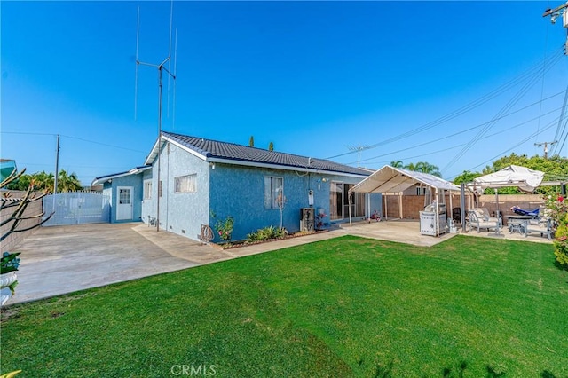 rear view of house with a yard and a patio area