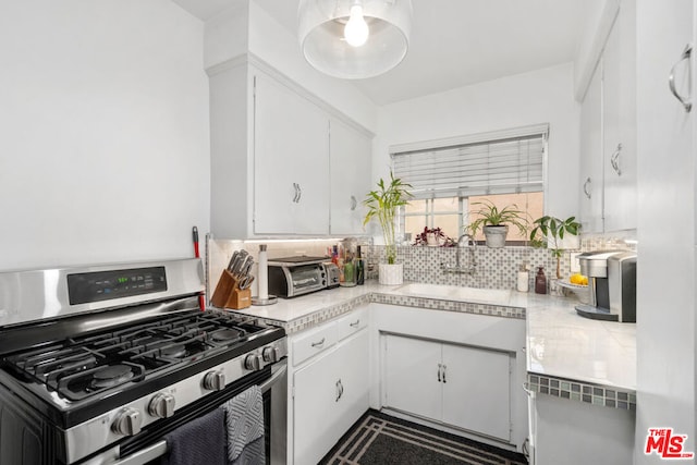 kitchen featuring white cabinets, tasteful backsplash, stainless steel range with gas stovetop, and sink