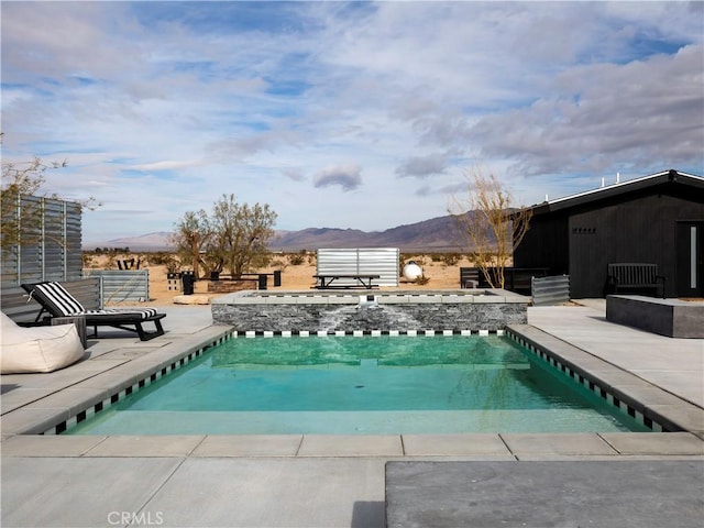 view of swimming pool with a mountain view and a patio