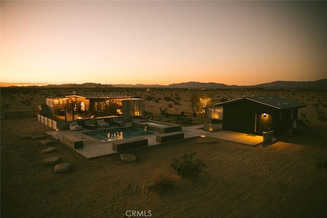 exterior space featuring a mountain view, a patio, and an in ground hot tub