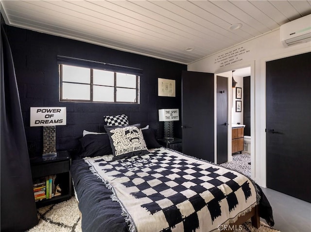 carpeted bedroom with a wall unit AC and ensuite bathroom